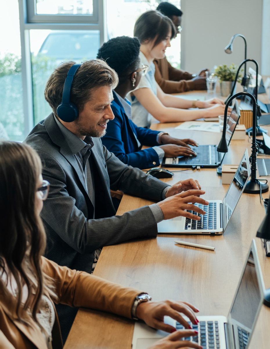 Kollegen am Schreibtisch mit Kopfhörern.